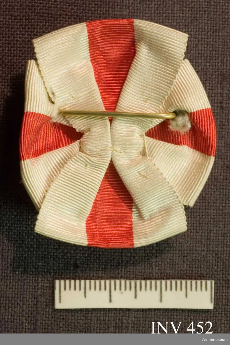 Brosch av förgylld silver och blå emalj. Med drottning Sophias initialer "D S F" krönt med en kunglig, sluten krona. Kronan är fylld med röd emalj.

Bokstävernas höjd: 14 mm. På ramen kartuscher.

På baksidan är broschnålen genomstucken ett band i rött och vitt ripsband som är förenad som en rosett och synlig från framsidan 7 mm.

På baksidan stansat "G.Möllenborg Kongl.Hovjuvelerare Stockholm.