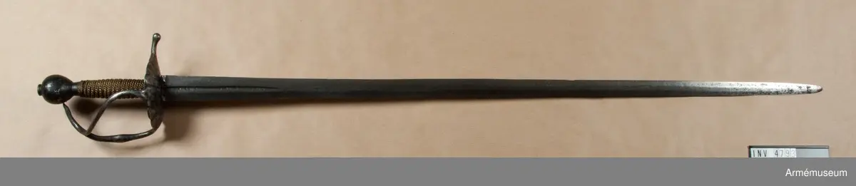 Klingan märkt med P-stämpel och "(CO)". Bredd vid fästet: 34 mm.

Fästet med upp-/nedvänd, äggformig knapp m icke ursprunglig låg nitknapp. Kavellindning av snodda mässingstrådar i reglementsenligt mönster är av senare datum. Randad, flat, svärtad parerplåt; något mindre på insidan än på utsidan. Dess kant är svagt runduddad och den undre sidan har en ornering i form av radialt ordnade ränder. "Nr: 191" inputsat. Handbygeln m förtjockning på mitten är intappad i knappen. Från parerplåten utgår en svängd, yttre sidobygel och ansluter till handbygelns övre del. Parerstången nästan rakt utstående m ett droppformigt avslut. Från parerplåtens insida utgår vertikal tumbygel. 

Klingan tveeggad m flat ås och hålslipning på bägge sidor. I dessa äro inslagna otydliga bokstäver "(CO)" och P-stämpel.