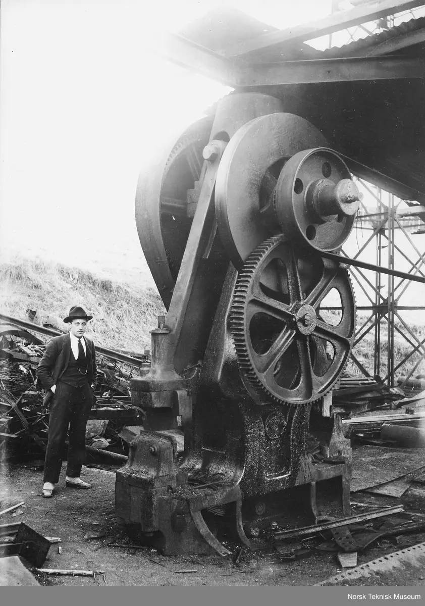 Skrapjernsplassen til Christiania Spiger og Valseverk. Alfred Blaker ved skrapjernssaksen. Saksen er bygget på Nylands mek. Verksted og klippet inntil 5/4" plater