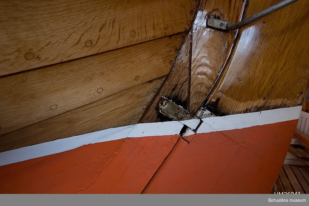 Spetsgattad. Klinkbyggd. Bord och spant av ek. Borden är nitade.
Däck av oregonpine. Ruff av mahogny och oregonepine (taket). Masten (H 10,3 m) och bommen (L 3,1 m) är gjorda av oregonpine.
Tidigare var båten gaffelriggad men i samband med en ombyggnad 1952 fick hon däck, ruff och en ny modern rigg samt kryssfock och storsegel av bomull tillverkat av Hasses segelmakeri i Göteborg, se UM026494 - UM026495. Se Länkade filer under Tilläggsinformation.
På sittbrunnens sarg sitter en namnskylt i trä; "NYMF".
Ett blått kapell, sprayhood, med två vita stänger från 1980-tal samt en båtshake förvaras i ruffen. Se Länkade filer under Tilläggsinformation.

Båten ägdes på 1930-talet av Karl Otto Jonasson. År 1941 sålde han den till Folke Gunnarsson och Rune Olsson. Fem år senare köpte Folke ut Rune.
Folke var med i Segelsällskapet FRAM i Göteborg. Båten kallades Nymf och hade nr 64 i segelsällskapet FRAM. År 1988 tog Karl-Erik Karlsson över båten.

Enligt Sveriges befolkning 1900 heter båtbyggaren Karl Alfred Fredriksson Stjërn, född i Kville 1857.
 
Litteratur: 
Börjesson, E, Börjesson, L., Dunér, m fl.: Kostern. Segelsällskapet Fram 100 år. 1896-1996. Göteborg 1996.
Sörenson, Reiners: Stjerns båtbyggeri på Galtö. Ur Träbiten nr. 93, Föreningen Allmogebåtar, Göteborg 1996.
Hasslöf, Olof: Svenska Västkustfiskarna, Stockholm 1949, sidan 296 ff,
Fredriksen, Christine: EBBA och NYMF - nöjesbåtar vid Bohuskusten. BOHUSLÄN. Årsbok 1999. Handel och hantverk. Bohusläns Hembygdsförbund och Bohusläns museum, s. 87-104.

Se Bilagepärmen UM26491: Träbiten nr 93 samt information från Segelsällskapet FRAM.
Gaffel och äldre bomullssegel finns el. uppgift från givaren kvar.
Uppgifterna kompletterade 2002-09-06/A-LS

Se Bildarkivet UMFA55001:1, familjebild från 1934 samt UM031358, prispokal från 1935.