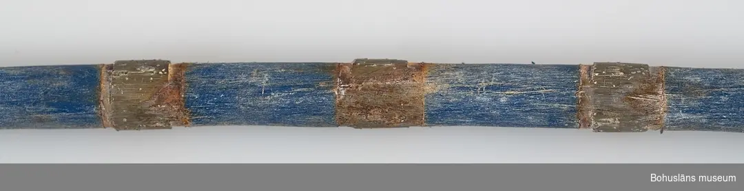 * Förvärvat från, forts.: industri, Evja Stenbrott
594 Landskap Bohuslän
503 Kön Man

Sex bitar av sågvajer av två olika fabrikat. Det ena med  genomskinlig plast, L 119 cm  (:1) samt  L 85 cm (:2), det andra med blå plast, L 30 cm (:3-6). 
(Coffeplast används idag (?).
Vajern är tillverkad av en stållina på vilken placerats diamantimpregnerade pärlor som sitter på jämnt avstånd med distanshållare av plast. Diamanten är syntetiskt framställd. Distans- hållarna skyddar linan från det nötande stenslammet och ger stadga och håller pärlorna centrerade och ger ett utlopp för vatten och slam från skåran. 

Vajersågningstekniken är lämpad för att öppna skikt, ta ut block från skiktet genom vertikala, horisontala och sneda snitt, skära ut vinklar, storlekar samt såga plattor ur block. Själva sågekniken beskrivs i teckningar  på s. 11 i produktbroschyren "Diamant Boart",
se Bilagepärmen UM27813.

Vajern löper runt med hög hastighet i en stor maskin som drar den runt. Sågytan bevattnas kontinuerligt under sågningen.  Såghastigheten varierar mellan 1.5 - 5 kvadratmeter i timmen, beroende på vinkel och typen av granit. Vajern kan såga ca 17 kubikmeter, sedan är den utsliten. Livslängden beror på stenens struktur. 

Fördelarna med tekniken presenteras på följande sätt i produktbroschyren ovan, s. 7: 
-hög såghastighet, snabb start av sågningen, minimal bevakning nödvändig, låga investeringskostnader, hög sågkvalitet vilket minskar slöseriet av material, låg ljudnivå. 

Den diamantimpregnerade wiren för granit kom på marknaden 1985. Man började använda denna teknik för ca fem år sedan i Evja Stenbrott. Då var vajersågning någonting helt nytt som man trodde skulle slå ut klingsågningen, ett sågmoment där ett block sågas upp i många tunna skivor eller plattor med en rund stålklinga med ett yttersta segment av diamant.  Så har det emellertid inte blivit. "Det har inte slagit helt väl ut. Sågen är nog bra, men vajern hänger inte med. Den går av. Det är svårt att såga rakt, parallellt med vajer. Då fungerar det bättre med klinga på de stationära stationerna. Men i brottet fungerar det bättre än på de stationära platserna. I berget har den slagit ut jetbränningen. Det hörs nästan ingenting när man sågar i brottet med vajer." Diamantvajerns ljudnivå för operatören är 70 dB enligt leverantören.

Det finns två stationära vajermaskiner på Evja Stenbrott (?)  Dessa är av japansk tillverkning. "Om vi hade väntat ytterligare ett år hade vi fått en annan såg." Tekniken inom detta har blivit mer avancerad under de senaste fem åren. Idag är allt helt datorstyrt. "Vi lärde oss denna sågen själva. Japanerna kom och visade, sedan fick vi lära oss själva."

Diamantvajersågen i brottet är portabel och löper på en räls. Evja Stenbrott hyr in denna teknik från ett norskt företag. En såg som denna kostar runt två miljoner kronor.  Genom att hyra in tjänsten behöver man inte belasta företaget med kostnader för investeringen,  underhåll och utbildning.

Den tidigare tekniken med jetbränning är effektiv men mycket störande i brottet. Tekniken introducerades på 1960-talet. (Se Quirin s. 92-93 nedan.) Jetbränningen dammar och ryker, bullrar och larmar med ett öronbedövande dån upp till 135 dB. Den avger även mycket avgaser. "Sten och damm ryker runt i brottet och det stör miljön. Det hörs långt." P g a detta används inte jetbrännaren under ordinarie arbetstid. Man har dock inte helt upphört med jetbränningen. Den används fortfarande men väldigt litet och då till speciella arbeten. Det kan vara när en klack i i berget skall sågas ut som inte går att komma åt med diamant- vajern. 

För information om Evja Stenbrott och insamlingen, se vidare UM27813.