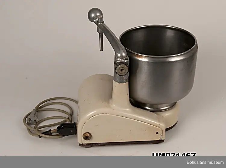 Hushållsassistent från 1940-talet av märket Electrolux.
Stomme med elmotor av ursprungligen beigemålat gjutjärn med löstagbar arm, armfäste och övre stativ av aluminium. Dämpande gummiknoppar undertill och på ena sidan. Rostfri, löstagbar skål. Elsladd av grått gummi med kontakter av bakelit.
Tillhörande redskap i metall och björk; blandare, degrulle av trä, rivjärnssats och skrapa av trä. Givaren kommer att komplettera med grönsakskvarn, köttkvarn, korvhorn. 

Efter många års flitig användning var färgen på maskinen väldigt sliten varför den målades om. På sidan har texten ELECTROLUX funnits.