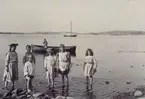 Barn som känner på vattentemperaturen med fötterna. Från Styrsö Villabron i Göteborgs skärgård