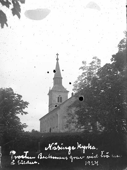 Enligt text på fotot: "Näsinge kyrka. Prostens Backmans grav vid trädet å bilden. 1924
Enligt notering: "Näsinge kyrka 22 juni 1924".".