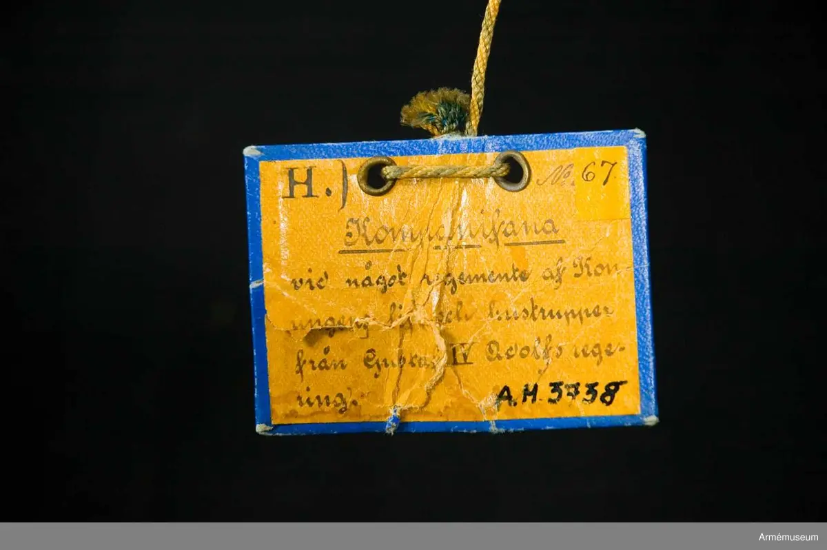 Fanduk av vit sidenkypert i tre våder, broderad med guld omvänt å båda sidor: I mitten Gustaf IV Adolfs namnchiffer "GA" under kunglig krona med foder av rött silke samt stenar i olikfärgat silke. I hörnen slutna, kungliga kronor liknande namnchiffrets. Duken är kantad med vitt sidenband, fäst med vitt sidenband och förgyllda spikar. Stång av furu, gråvitmålad. Diameter - ovan fanan 3 cm, nedom 3,5 cm. Holk av förgylld mässing.
Märkt "L.G." på stången.