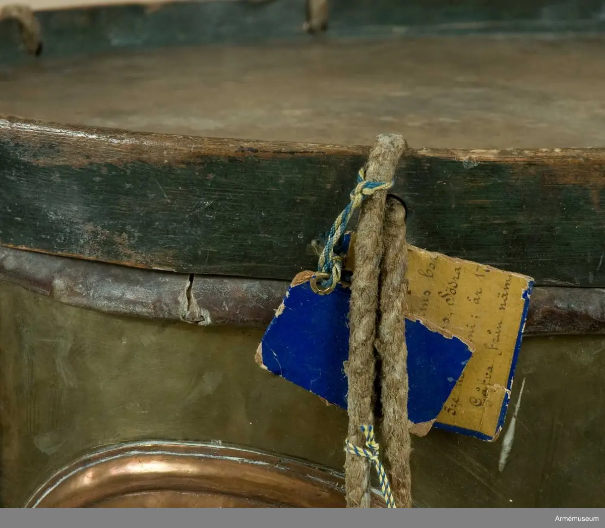 Grupp B III.
Gjord av mässingsplåt med grönmålade träramar. Snörad. Snarrsträngar har funnits, men saknas nu. Vingskruven, med hållare, för dessas spännande finns dock kvar. På hållaren är ingraverat: "Skänkt af P. (J) G. Bergman, Fendrich vid Borg.skapets Södra Bataile 5:te Comp. den 3 April 1764". Har en påsatt, oval kopparplåt med S:t Eriks bild, därikring är ingraverat: "Södra Batallions Femte Compagnie". Bärrem av brunt läder. Gåva från Borgerskapets militärkorpser. Tillhört Stockholms borgerskaps infanterikår./Mars 1939 A Lilliehöök. 