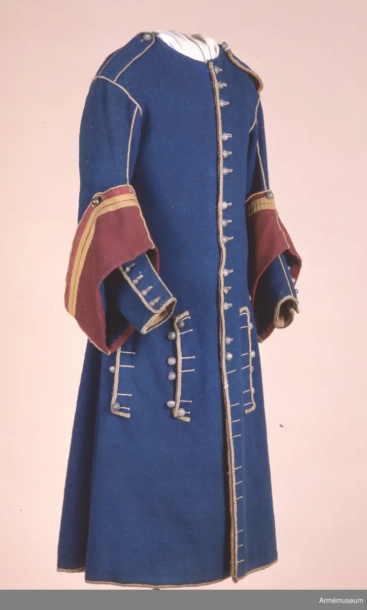 Grupp C I.
Uniformsrock-, Frankrike. Justaucorps, sannolikt 1680-t. Antal knappar i original: Knäppning mitt fram 23 st (ursprungligen 24). Rockens vänstra sida 4 st (urspr 6), den högra sidan 6 st, vänster yttersida 4 st (urspr 6), höger yttersida  3 st (urspr 6). Vänster och höger axel 1 st på var. Vänster och höger ärm 4 st  på var ärm. /AA nov 1986.