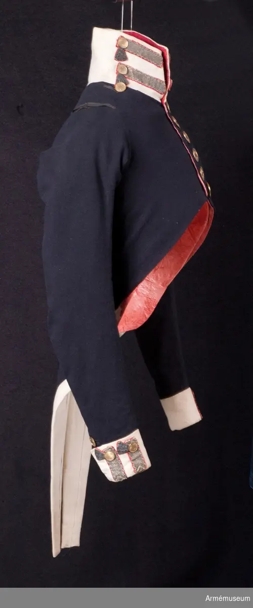 Mörkblå frack med vita detaljer och förgyllda mässingsknappar.

Fracken är sydd av blåsvart fint kläde, med vit, hög krage som i nacken bak går ned i en spets. Uddig guldgalon på kragen och tre knappar av mindre modell än mitt fram. Sidenband på båda axlarna för fastsättning av epåletter. Ärmuppslagen är vita med två guldgaloner på varje med knappar upptill. På bakstycket blindfickor med guldgalon på röd matta; tre stycken med knappar nedanför på frackskörten. Skörten är fodrade med vitt, tunt ylletyg som även använts till uppviken. Två granater som är en symbol för grenadjärerna är broderade  med metalltråd längst ner i skörtens spetsar.
I livet bak sitter två knappar som dekoration. Fram knäpps fracken med 6 stora guldknappar med tre kronor på räfflad botten.
Fracken är konstruerad med fram- och sidstycken i ett. Sidorna går ner och bildar tudelat frackskört bak. Båden har varit fodrad med rött fint ylletyg, troligen en rask. Under konservering har fodret ersatts med rosa sidentyg i sidorna. Ärmarna är fodrade med fint vitt linne, men den nederste delen av ärmen har en infodring av samma röda tyg som i bålen.