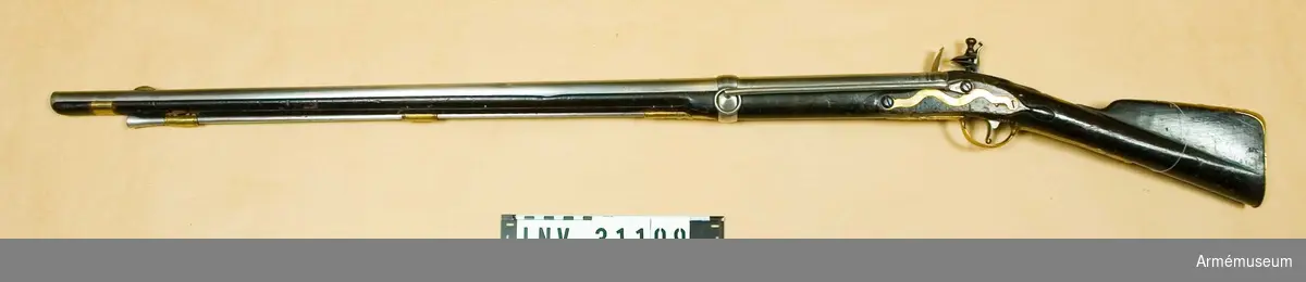 Karbin med flintlås.
Vapnet överensstämmer helt med A.M. 31074. På pipans översida finns Jönköpings krönta ring i två olika storlekar, en stämpel med P.RS (vål Peter Rundberg, men bokstäverna kunna vara PRC) samt desutom numret 122. På undersidan sitter Jönköpings krönta ring, vilken, liksom på översidan, är mera kronliknande än vanligt.

På låsbleckets utsida finnes en stämpel med S.L och med månguddig stjärna. Till vänster om varbygelns främre arm sitter på stockens undersida ett stockmaka remärke, bestående av bokstäverna DG. Baktill på kolvens vänstra sida är numret 122 inslaget. På bakplåtens flik, på karbinstångens bakre arm samt på varbygelns bakre arm finnes samma stämpel som på låsblecket. På bakplåtens flik är desutom numret 122 inslaget. På sidbleckets insida finnes en stämpel med bokstäverna C.S. På laddstockens stötyta är ett B inslaget. Se i övrigt A.M. 31074.