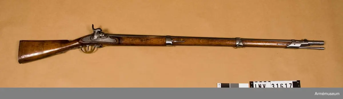Grupp E II. 

Nominalkaliber 17,5 mm, verklig kaliber 18 mm.
Pipan är rund och blank. Snäckan är stor. Dess antändningskanal är bruten i vinkel och den horisontala grenen tillslutes utåt av en på snäckans utsida placerad, med fyrkantigt huvud försedd skruv.

Framtill på pipan finnes ett båtformigt mässingkorn och på svansskruvsstjärten sitter ett högt ståndsikte. På pipans översida är inslaget BGC= Bestaendig Gevaer Commission (efter 1829) och B - 382.

På vänstra sida står 12.L.I.B.4 C.29 R ( 12:e linjeinfanterieregementet, andra bataljonens 4:e kompani 29).

Låset har svagt kullrigt bleck och är av Kyhls konstruktion, d.v.s. hanen är placerad på bleckets insida. framtill på låsblecket är inslaget B - 382. Stocken synes vara av bok.

Kolven har kindstöd på vänstra sidan.

Pipan fasthålles i stocken av den uppifrån isatta korsskruven samt av tre flata reglar, som gå i häften på pipans undersida och i skodda hål på framstocken. Dessutom finnes ett fjärde häfte för den främre rembygelns skruv, som ävenledes går genom framstocken.

Beslagen äro av mässing och bestå av bakplåt, varbygel, sidbleck, fyra rörkor och näsbleck. 
Den bakre rembygeln har varit fäst vid varbygelns bakre arm.

Laddstocken är av stål. Den får nog anses vara konisk, och har visserligen stort huvud i den ena änden, men tjockleken tilltager koniskt mot den andra, som dock ej är så tjock som laddstockshuvudet. 
Modellbeteckning enligt kapten Stöckel.//J. Alm 1937.