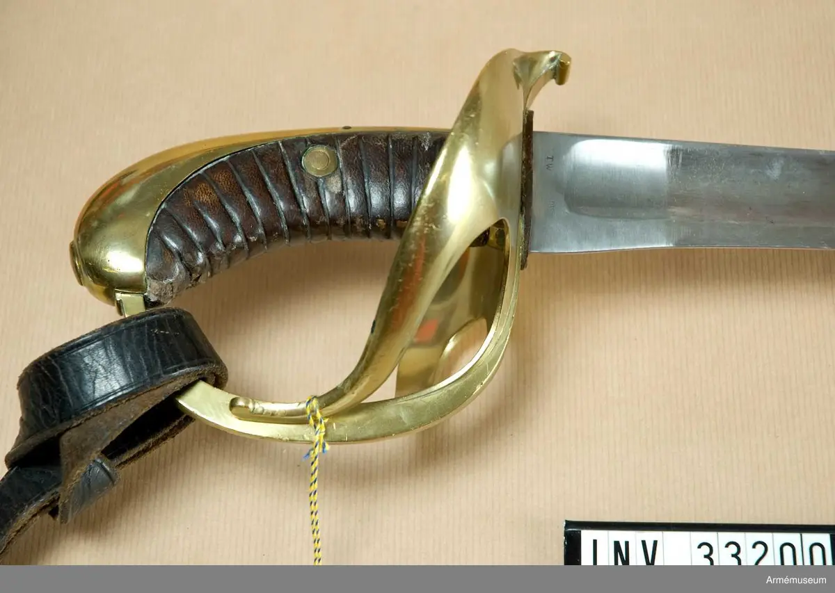 Stålklinga med ässingsfäste och läderklädd kavel.