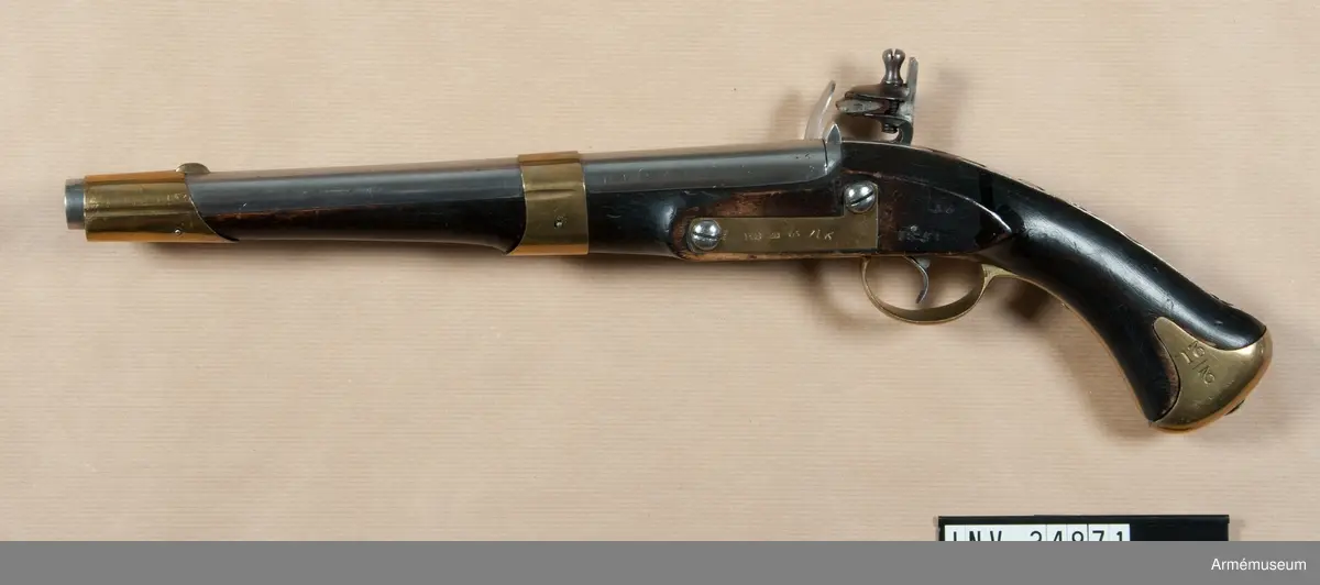 Flankörpistol m/1807 av Helvigs konstruktion, med flintlås. Kaliber: nominal 16 mm, verklig 16,55 mm. PIPAN är rund. Svansskruven har baktill en hake, som är inpassad i ett hål på det vid stocken fästa svansjärnet. Ett båtformigt mässingskorn sitter 4,1 cm bakom mynningen. På svansjärnet sitter ett högt ståndsikte. Svanskruvsjänet fasthålles av en uppifrån isatt korsskruv. På pipans översidan monogram av I T samt G B och en otydlig stämpel. På vänstra sidan numret 46 och på undersidan ett R. Loppet är slätborrat.

LÅSET har platt bleck, fängpannearm och eldskärm. Studeln har en egendomlig, kantig form. Slag- och eldstålsfjädrarna är så krökta att den främre låsskruven går inom deras bukter. På bleckets insida monogram av I M.

STOCK av björk och svart. På V sidan bakom sidblecket inslaget nummer 46 och årtalet 1811. Till V om varbygelns främre arm står nummer 29.

BESLAG av mässing. Kolvkappan har rätt korta, avrundade flikar och är hoptryckt från sidorna. Den fasthålles av en skruv i centrum. Varbygelns bakre arm går ned till kolvkappan och fasthålles av en skruv. Den korta främre varbygelsarmen har docka. Sidblecket är platt och böjt i rät vinkel. Pipan fasthålles av två band, vilka kvarhållas av stift. Näsbandet är ganska långt, litet utskuret för kornet och har nedtill en kort, bakåtgående spets. Det nedre bandet har en kort, framåtriktad spets. På sidbleckets utsida numret 46, G.S, PLB, otydlig kronstämpel och en stämpel med tre bokstäver, av vilka den första är oläslig och de två andra P S. På insidan siffran 5. På kolvkappans vänsta flik en understruken tvåa och under detta "21".Pistolen har "anslagsjärn" (se AM 34897) och är sålunda avsedd för löskolv.

Ett par pistoler m/1807 bestå av en blänkare- eller flankörpistol, lika den ovan beskrivna, samt en studsarepistol (se AM 34897). Till varje pistolpar hörde en löskolv, även kallad "löst anslag" och en lös järnladdstock. Löskolven och laddstocken passa till bägge pistolerna.
