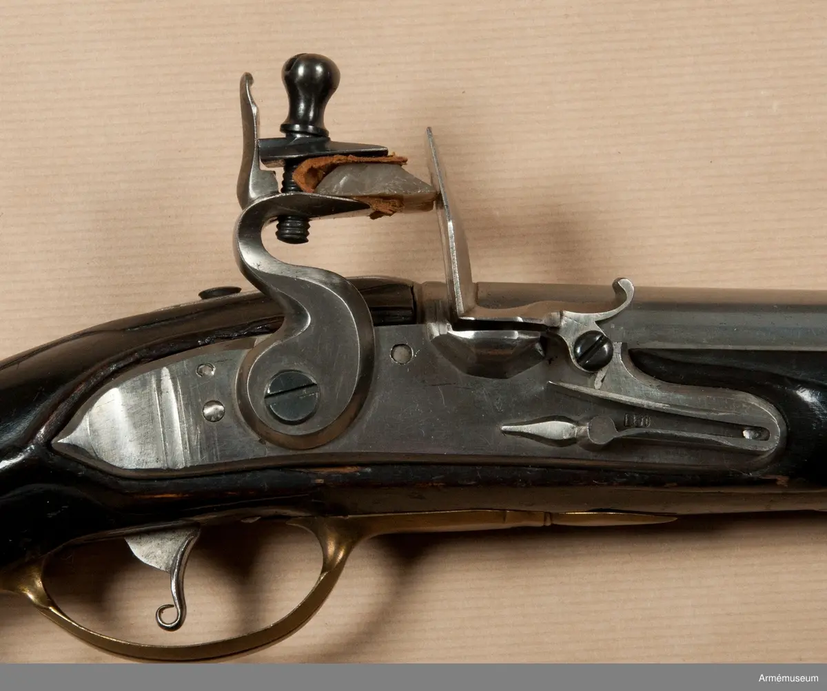 Pistol med flintlås.
Beslag av mässing. Laddstock av trä med mässingsbeslag. På kammarstycket ett krönt F samt bokstaven Ö. På kolvhalsen en mässingsmedaljong med Gustaf III:s krönta namnschiffer. På kolvhalsens H sida nummer 25 inskuret och på dess motsvarande bokstäverna V B. Vid kolvknappen en ring av järn fästad, pistolen tycks vara par med AM 1932:4769.