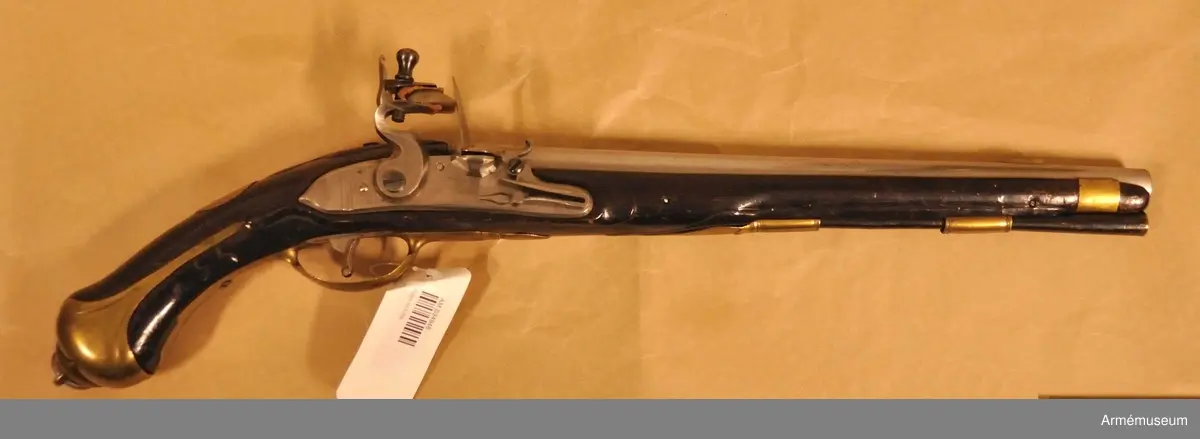 Pistol med flintlås.
Beslag av mässing. Laddstock av trä med mässingsbeslag. På kammarstycket ett krönt F samt bokstaven Ö. På kolvhalsen en mässingsmedaljong med Gustaf III:s krönta namnschiffer. På kolvhalsens H sida nummer 25 inskuret och på dess motsvarande bokstäverna V B. Vid kolvknappen en ring av järn fästad, pistolen tycks vara par med AM 1932:4769.
