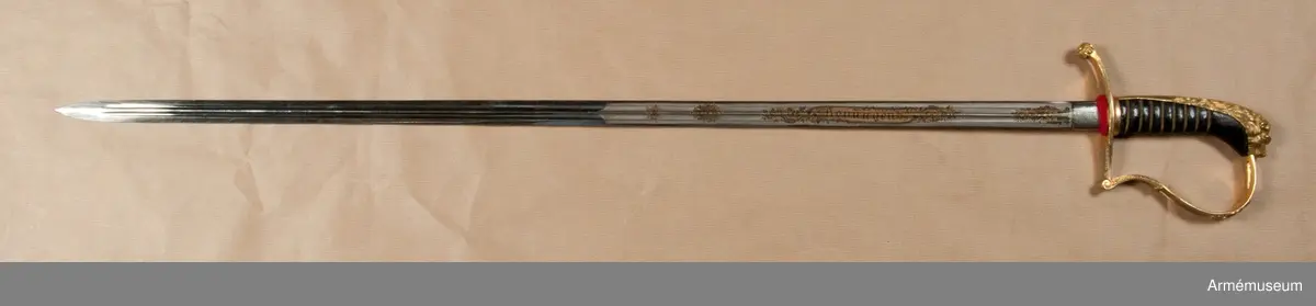 Klingbredd upptill 222 mm. Sabeln är fullkomligt AM 39928 men klingan är kortare. Den officiella längden på klingor m/1899 är 80 cm. Vid vapnet är fästat en fastställningslapp.