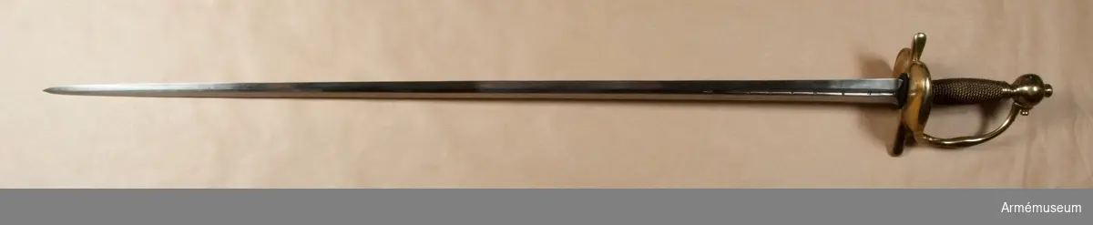 Klingan är tveeggad med flata åsar. På bägge sidor finns upptill en omkring 193 mm lång blodrand. Nedanför blodrandens slut finns på klingan en pilspetsliknande stämpel. 

Fästet är av mässing och av drabanttyp. Knappen har närmast formen av ett vid polerna tillplattat klot, dock med skarp rygg på fram och baksidan. Diametern i sidled är 37 mm, men över ryggarna 40 mm. Höjden är 31 mm. Nitknappens diameter är 16,5 mm, dess höjd 10 mm. Den är instrypt på mitten och har en spetsoval, 20 mm lång fot. Halsen är instrypt på mitten och upptill spetsoval samt 13,5 mm lång. En rand eller snarare avsats markerar gränsen mellan knappen och nitknappen samt mellan knappen och halsen, en dylik går även runt halsens nedre del.
Kaveln har fram och bak en flat kant, men sidorna är avrundade. Den har upp och nedtill ett 9 mm brett beslag av tunt mässingsbleck, vilket är prytt med två ränder. I övrigt är kaveln lindad med två mässingstrådar, en smalare och en tjockare, båda hopsnodda av två parter, den ena höger-, den andra vänstersnodd. Lindningen har Iossnat.
Parerstången är rak och har spetsovalt tvärsnitt. Ändarna är avrundade och parerstången vidgas mot dessa. Avståndet mellan främre eggen och parerstångens framända är 68 mm, men från den bakre eggen till stångens bakända 55 mm. Den största tjockleken är för den främre armen 10 mm, men för den bakre 8,5 mm. Den största bredden är för bägge armarna 16 mm. Avståndet mellan klingans mitt och parerplåtens ytterkant är 45 mm, men mellan klingans mitt och innerkanten 40 mm.