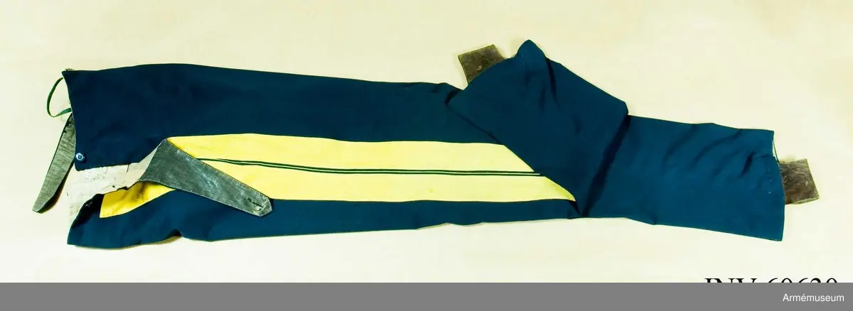 Mörkblå långbyxor med dubbla gula revärer i sidorna.

Byxorna är sydda av fint mörkblått kläde och är konstruerade med två fram- och två bakstycken, ett litet ok bak och hel lucka fram som knäpps i varje sida med en knapp. I varje sida av luckan sitter vidare en spänntamp fodrad med brunt linne- eller hampatyg som är avsedd att spännas ihop baktill för att reglera midjevidden.
Byxorna är ofodrade men har infodring i midjan och i luckan av oblekt linne- eller hampatyg, och ovanpå detta ytterligare en (troligen sekundär) infodring av oblekt bomullstyg. De har sytts om vid minst ett tillfälle då en mycket bred kil har satts in i grensömmen bak för att öka vidden.
Inuti byxorna sitter en förstärkning av oblekt bomullstyg i grenen. I byxbenens sidor sitter ca 5 cm breda dubbla revärer av fint gult kläde med en smal passpoal av gult kläde mellan. Nertill i fållen av varje ben sitter fastsydda ca 7-8 cm breda hälremmar av brunt skinn, samt på benens insida framtill en förstärkning av oblekt linne- eller hampatyg. Byxorna har fyra knappar fram i linningen och två bak för fastsättning av hängslen. Samtliga knappar är av svartlackad metall.
Byxorna har påskrift med svart bläck på luckans insida:
"46,371. Tillh. Genereallöjt. M. Thulstrup. G. af. enkefru H. C. Thulstrup".