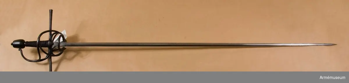 Den smala, tveeggade klingan har flata åsar. Längst upp har den en cirka 5 cm lång ansats, som har rektangulärt tvärsnitt. Ansatsen har på var sida längs långkanterna en ingraverad rand, och på var sida är en halvmåne inslagen. Stämpeln är en tysk efterbildning av Toledosmeden Juan de Lunas stämpel.

Fästet är av svärtat järn. Knappen har cirkelrunt tvärsnitt och  avsmalnar något uppåt. Översidan är svagt och undersidan är starkt avrundad. Nitknappen är närmast cylindrisk och skiljs nedtill genom en instrypning från den lilla avrundade foten. Halsen är kort, har cirkelrunt tvärsnitt och skiljs genom en instrypning från knappen. Träkaveln avsmalnar något uppåt. Dess eggsidor är flata, men flatsidorna är svagt kullriga. Upp- och nedtill finns en smal krans av snodd järntråd. Kavellindningen består av en ganska smal höger- och en liknande vänstersnodd järntråd, men ursprungligen har det tydligen funnits flera trådar.
Parerstången är rak och har cirkelrunt tvärsnitt. Den vidgas rätt mycket mot de svagt avrundade ändarna. Från korsets undersida går på var flatsida en kort trekantig flik nedåt. Från korset vid var och en av klingans eggsidor går en stor fingerhake nedåt. Fingerhakarnas nedre ändar förenas på yttersidan genom en horisontal "åsnehovsbygel" och från samma ändar utgår också en stor, snedställd parerbygel, vars översida står något över parerstången. Från mitten på sistnämda bygel går en spång till handbygeln, med vilka den förenas något nedanför bygelns mitt. På innersidan går en nedtill trekluven gaffelspång från fingerhakarnas nedre ändar till handbygeln, vilken den träffar något nedanför bygelns mitt. Alla byglar och spänger har cirkelrunt tvärsnitt.