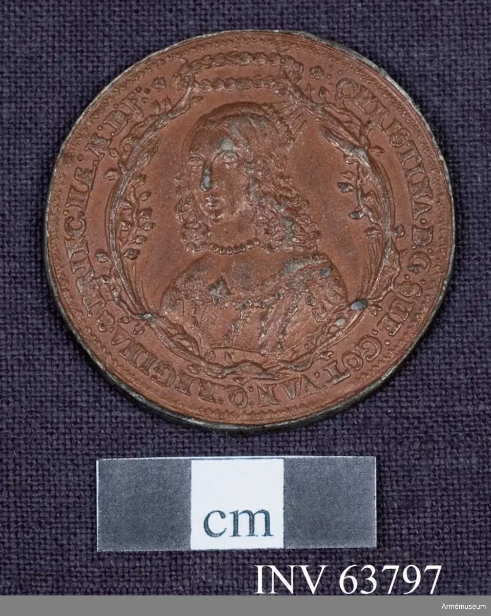 Medalj av 13. storleken. Freden vid Brömsebro den 13 augusti 1645. Medaljen är av brungjort tenn. Kring kanten på båda sidor en fin ornamentsrand.

ÅTSIDAN: "*.:CHRISTINA D:G:SVE:GOT:VAN:Q:REGINA & PRINC: HAE:M: D: F:.*" Bröstbild, nästan framvänd, i prydlig dräkt med stålkrona på nacken. Om halsen ett enkelt pärlband, på bröstet ett smycke. Omgiven av två med lager omlindade palmkvistar, upptill samman- hållna av en lagerkrans.

FRÅNSIDAN: "*ET BELLO ET.PACE.TRIVMPHAT:.ANNO 1.6.4.5:." Två händer sträcks fram från skyar ur motsatta sidor. Den ena handen håller ett ymnighetshorn fullt av blommor och frukter ochh två olivkvistar. Den andra håller en stång med en kluven flagga och har vid armleden ett svärd fastbundet. På marken träd och örter. Överst tecken (hebreiska? Se bilaga.) inom en strålande båge. I avskärningen "H.W."