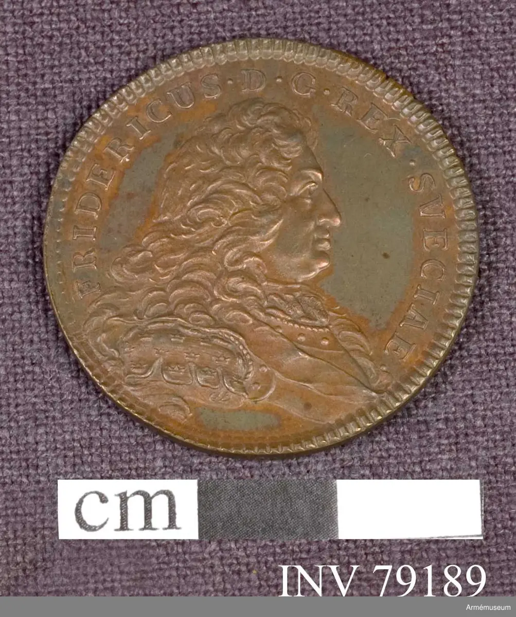 Grupp: M. 
Åtsidan: FRIDERICUS. D.G. REX SVECIAE. Bröstbild åt höger i harnesk med naglar i övra kanten, kronor på axelbetäckningen, halsduk och ordensband - Under armen ett svagt tecknat monogram, innehållande D.F. -Kanten på båda sidor strierad.

Frånsidan: DUCTORIBUS ADDIT HONORES. Svärdsordens storkors. I avskärningen: ORDO GLADII REST 1748. 

Graverad av D Fehrman.