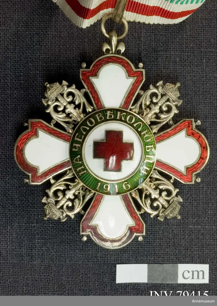 Halskors med Röda Korsets emblem. I band i färgerna vit-röd-grön.