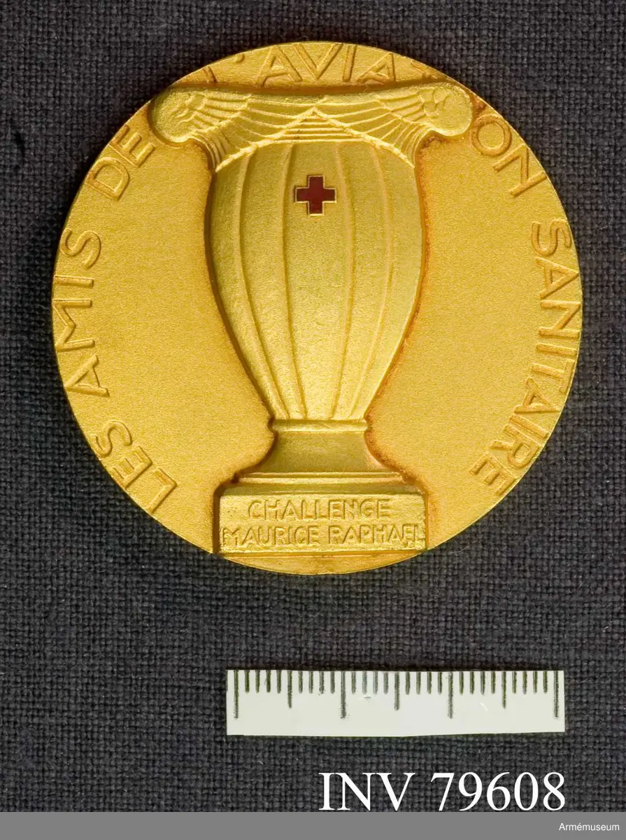 Rund medalj med text på framsidan: "Les amis de l'aviation sanitaire" (Vänner till medicinsk luftfart).

På baksidan "En temoignage de reconnaissance S.A.R. Le prince Charles" (Som ett tecken på tacksamhet HKH Prins Charles).