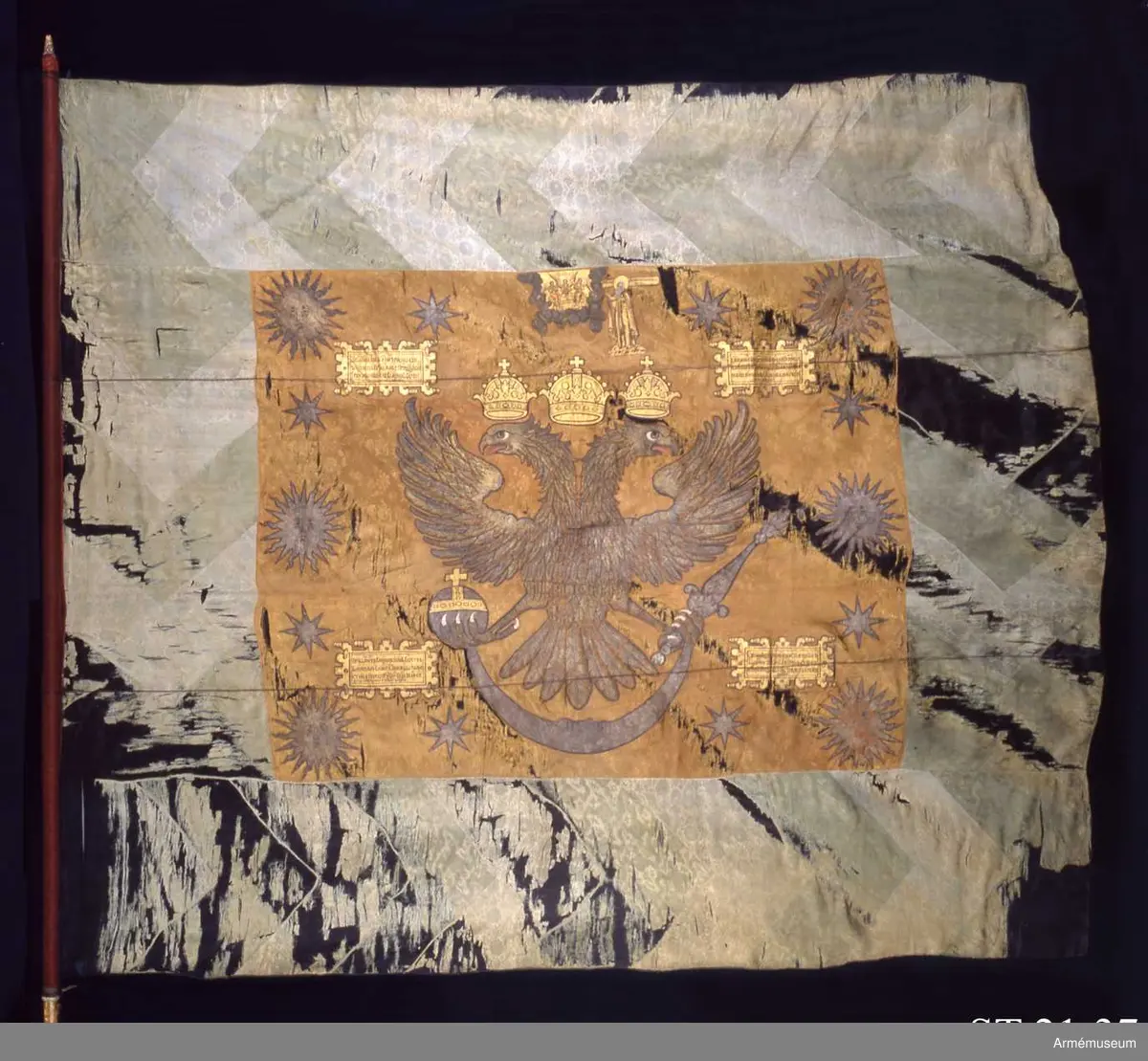 Fotfolksfana från den ryska staden Pskov.

Fanan har ett mittfält av ursprungligen röd kinesisk sidendamast, inom en bred blå och grön sicksackmönstrad bård. Den är dekorerad med intarsiabroderi och målade detaljer. Strumpan är av ylle.
På båda sidor av fanduken ses den tvåhövdade ryska örnen krönt med tre kronor vilka representerar de tre tsarrikena Kazan, Astrachan och Sibirien. Ovanför örnen syns den gammaltestamentliga framställningen av treenigheten samt bredvid helgonet Sergej av Radonesj. Örnen omgärdas på båda sidorna av sex solar och åtta stjärnor, samt 5 kartuscher med svart text på guldbotten.
Den ryska texten i kartuscherna lyder i översättning:
”Den 2 mars år 7201 (1693) under den tid, då regeringen fördes av deras högheter och storregenter, med Guds nåde tsarer och storfurstar Ivan och Peter Alexejevitj, hela, stora, lilla och vita Rysslands självhärskare, och under den tid, då överokolnitjen, vojevoden och guvernören över Nizjegorod Peter Matvejevitj Apraksin med närmaste män vistades i riket Pskov, lät stolniken Ivan Michailovitj Kokosjkin överste för Pskovs första streltserregemente, utföra denna fana. ”

Den kinesiska damasten är mönsterad med krysantemum, lotus, trädpion, granatäpple, Buddas-hand-citron samt olika värdeföremål.