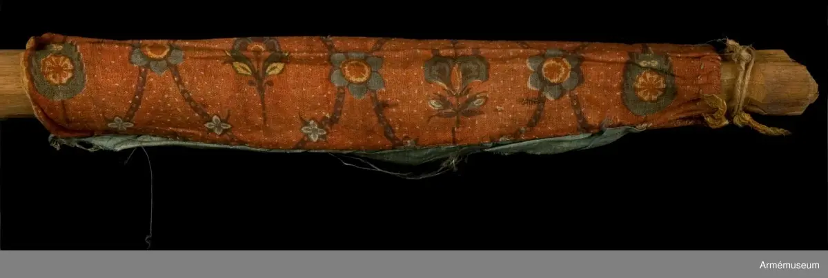 Duk av ljusblå kinesisk sidendamast med målad dekor föreställande helgonet Demetrius av Thessaloniki och slingor av blommor. Strumpa av rött linne.