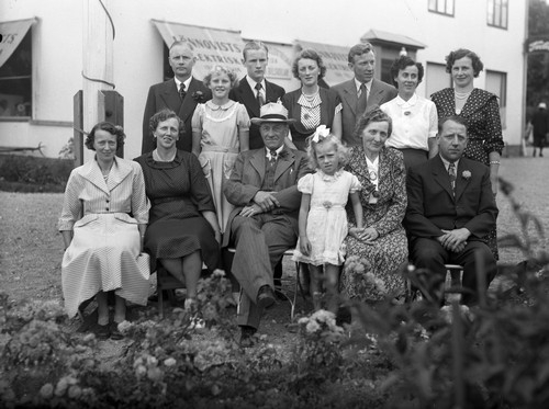 Familjen Sahlsten utanför Richard Sahlstens affärsfastighet Centrumhuset i Munkedal, 1949-1950
Personerna är (stående från vänster) Tage Eliasson (gift med Viola), Gunnel Eliasson (dotter till Tage och Viola), Sune Eliasson (son till Tage och Viola), Millicent ”Mimmi” Sahlsten (dotter till Rickard), Evald Rickard ”Rick” Sahlsten (son till Rickard), Britt Sahlsten (gift med Rick) samt Stina Sahlsten (född Jansson, gift med Erling). Sittande från vänster: Gulli Lundquist (född Sahlsten, dotter till Rickard), Viola Eliasson (född Sahlsten, dotter till Rickard), Rickard Sahlsten, Lisbeth Sahlsten (dotter till Erling och Stina), Hilma Olena Sahlsten (gift med Rickard) samt Erling Sahlsten (son till Rickard och bedrev taxirörelse fram till 1970-talet).