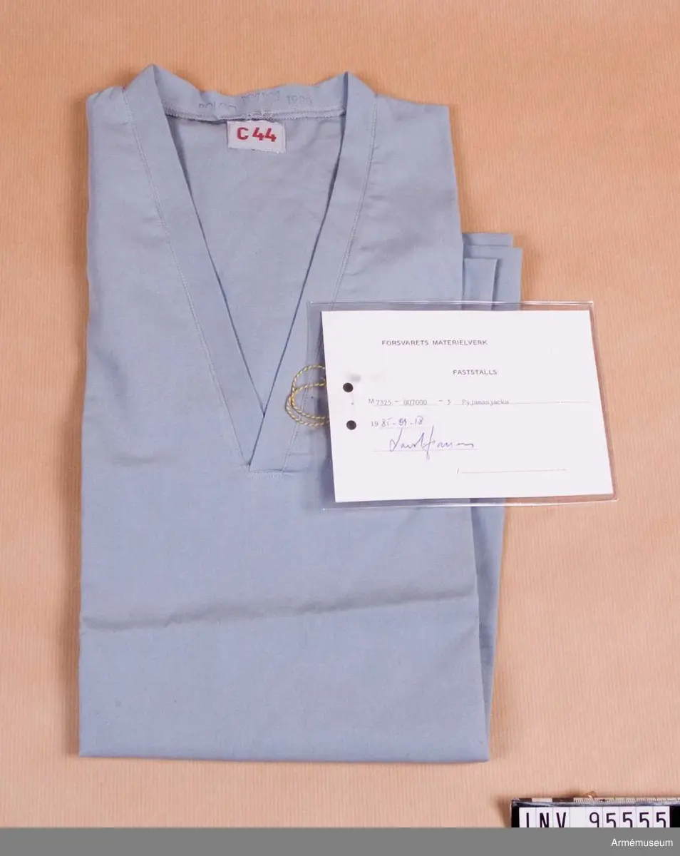 Vidhängande etikett: "Försvarets materielverk Fastställs M 7325-007000-3, Pyjamasjacka, 1985-09-18 (oläslig underskrift)".