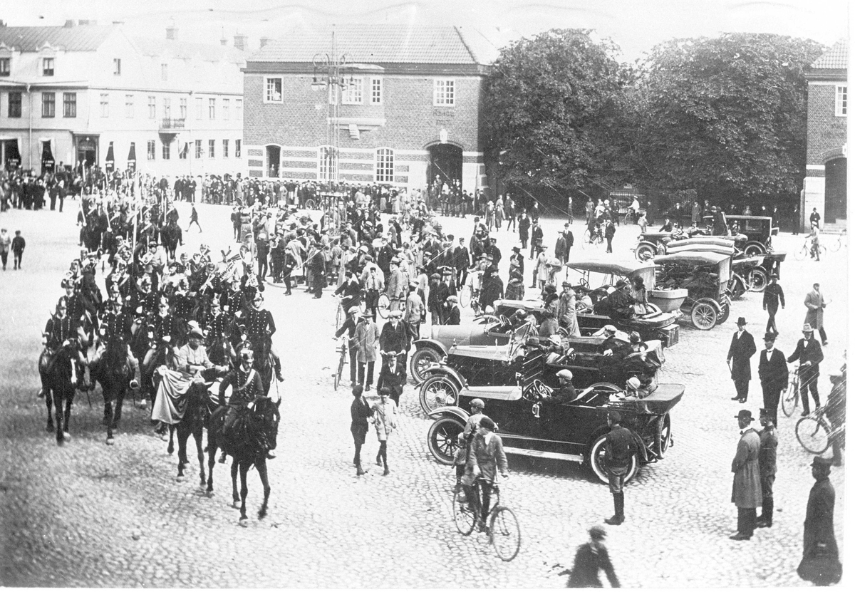 Wendes artilleriregemente A 3 övar högvakt på Stora torget i Kristianstad 1924. Soldaterna iförda uniform m/1872. Civila åskådare med bilar, cyklar och till fot följer övningen.