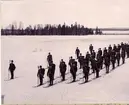 Volontärskolan vid Norrbottens regemente I 19 på skidor i Notviken, Luleå, vintern 1896. Soldaterna utrustade med gevär och en stav.