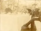 Män i Landstormsuniform sitter framför dukat kaffebord i trädgård i Löttinge, Täby, 1914.