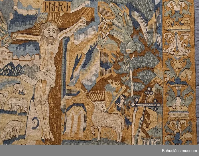 Bildvävnad från tidigt 1600-tal i lin, ull och hår. Flamskvävnad. Scener ur gamla och nya testamentet. I mitten Livets träd på vars vänstra sida återges scener ur gamla testamentet. På trädets högra sida den knäböjande jungfru Maria, Kristus på korset med omgivande bård, troligen efter försättsblad till tysk bibel 1500-talets förra hälft. Troligen nordtyskt arbete.


Ur handskrivna katalogen 1957-1958:
Gustavsbergstapeten
ÄVEN KALLAD GULLMARSBERGSTAPETEN.
DEPOSITION I APRIL 1947 AV GUSTAVSBERGS BARNHEM ENLIGT LAPPKATALOG. 242 x 205 cm.