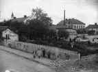 Strömberg & Olssons blomsterhandel, östra hörnet Eriksgatan - Ågatan, Enköping, vy från väster, troligen 1906. Betaniakyrkan till vänster i bakgrunden.