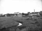 Sjukhuset med gamla epidemisjukhuset framför, t. h. tändsticksfabriken, Munksundet, Enköping, vy från öster, troligen ca 1905