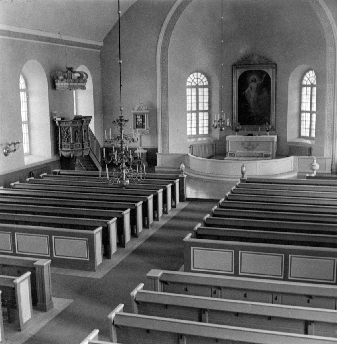 Interiör från Rogberga kyrka. Den invigdes 1868-09-06 av biskop H.G.Hultman. Altartavlan är målad av professor M.E.Winge, skänkt 1869. Predikstolen förfärdigad 1660 av Johannes Vern, Jönköping och år 1709 utsmyckad med fem statyetter av bildhuggaren Olaus Wiström. Ljuskronan närnast på bilden med 24 armar är skänkt av militärer, hantverkare, tjänare och mindre bemedlade. Ljuskronan vid altaret, daterad 1665, är en gåva av befallningsman Per Druvfa.