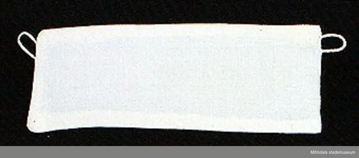 12 par vita lösmanschetter använda tillsammans med långärmade plagg. En del märkta med nr 41. 02253_1 L: 160 mm B: 55 mm._2 L: 160 mm B: 45 mm._3 L: 170 mm B: 60mm. Ribbat tyg._4 L: 190 mm B: 55 mm. Ribbat tyg._5 L: 200 mm B: 50 mm. Hålsömsprydda._6 L: 165 mm B: 80 mm. Hålsömsprydda (ej stärkta, märkta 15)._7 L: 160 mm B: 80 mm. Hålsömsprydda._8 L: 200 mm B: 50 mm. Hålsömsprydda._9 L: 180 mm B: 50 mm. Öglemönstrad spets längs kanten._10 L: 170 mm B: 55 mm. Smal spets längs kanten._11 L: 160 mm B: 45 mm. Spets längs kanten._12 L: 165 mm B: 50 mm. Ögleartad spets längs kanten.Paren förvaras i en tom chokladask (Cloetta Bristol praliner). Dessa har använts av vårdarinna Karin Hasselberg på Stretered.