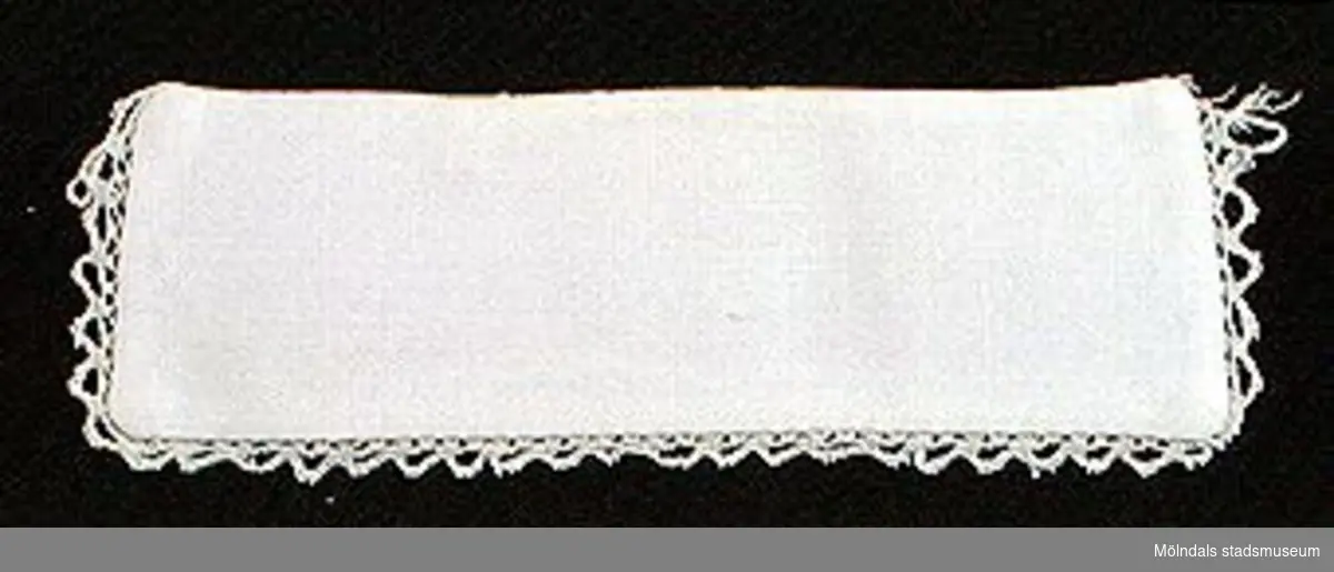 12 par vita lösmanschetter använda tillsammans med långärmade plagg. En del märkta med nr 41. 02253_1 L: 160 mm B: 55 mm._2 L: 160 mm B: 45 mm._3 L: 170 mm B: 60mm. Ribbat tyg._4 L: 190 mm B: 55 mm. Ribbat tyg._5 L: 200 mm B: 50 mm. Hålsömsprydda._6 L: 165 mm B: 80 mm. Hålsömsprydda (ej stärkta, märkta 15)._7 L: 160 mm B: 80 mm. Hålsömsprydda._8 L: 200 mm B: 50 mm. Hålsömsprydda._9 L: 180 mm B: 50 mm. Öglemönstrad spets längs kanten._10 L: 170 mm B: 55 mm. Smal spets längs kanten._11 L: 160 mm B: 45 mm. Spets längs kanten._12 L: 165 mm B: 50 mm. Ögleartad spets längs kanten.Paren förvaras i en tom chokladask (Cloetta Bristol praliner). Dessa har använts av vårdarinna Karin Hasselberg på Stretered.