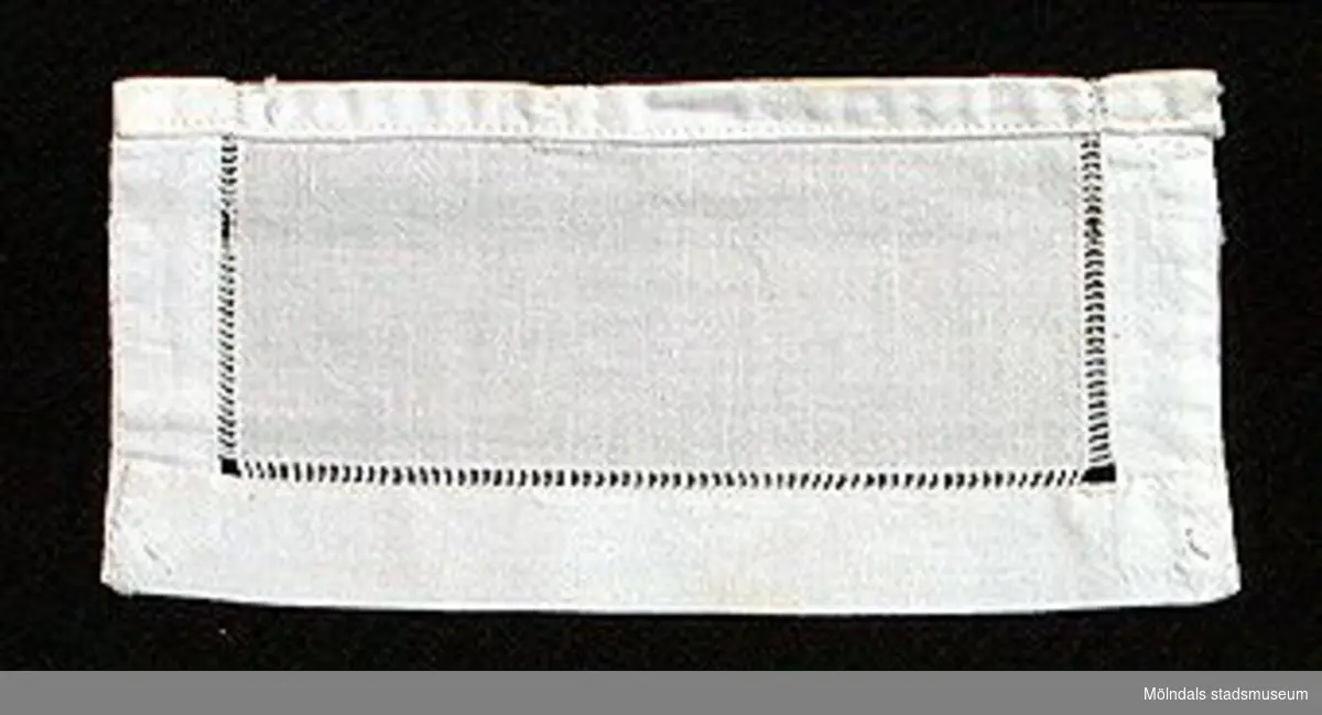 12 par vita lösmanschetter använda tillsammans med långärmade plagg. En del märkta med nr 41. 02253_1 L: 160 mm B: 55 mm._2 L: 160 mm B: 45 mm._3 L: 170 mm B: 60mm. Ribbat tyg._4 L: 190 mm B: 55 mm. Ribbat tyg._5 L: 200 mm B: 50 mm. Hålsömsprydda._6 L: 165 mm B: 80 mm. Hålsömsprydda (ej stärkta, märkta 15)._7 L: 160 mm B: 80 mm. Hålsömsprydda._8 L: 200 mm B: 50 mm. Hålsömsprydda._9 L: 180 mm B: 50 mm. Öglemönstrad spets längs kanten._10 L: 170 mm B: 55 mm. Smal spets längs kanten._11 L: 160 mm B: 45 mm. Spets längs kanten._12 L: 165 mm B: 50 mm. Ögleartad spets längs kanten.Paren förvaras i en tom chokladask (Cloetta Bristol praliner). Dessa har använts av vårdarinna Karin Hasselberg på Stretered.