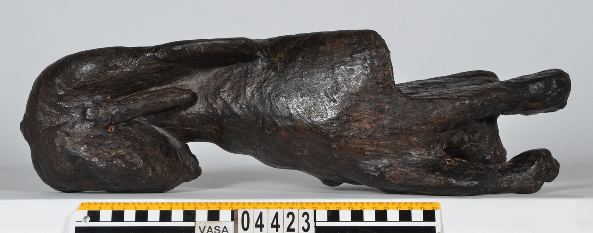 Skulptur av ett litet, liggande lejon med utsträckta framben och hopdragna bakben.
Lejonet är riktat mot vänster, sett från betraktaren. Det snett hållna huvudet återges i det närmaste i en face. Större delen av svansen saknas. Den befintliga delen av svansen avtecknar sig mot lejonets vänstra lår.

Lejonet är endast delvist rundskulpterat. På baksidan, i höjd med huvudet och höger framben, återfinns ett stort, snett urtag som bildar en slät anliggningsyta. Skulpturens framparti är således endast till hälften så tjockt som dess bakparti.
Bakkroppen är kraftigt sliten och skadad. Vänster bakben saknas, liksom större delen av svansen.

Text in English: Sculpture of a small reclining lion with its forelegs extended and its  hind legs tucked beneath its body.
Facing to the observer''s left, the head, held crookedly, is nearly en face. A large part of the tail is missing, and the remainder curves towards the left hind leg.

The lion is only partly three-dimensional. On the rear at the head height and at the right foreleg a large oblique hole forms a flat area for attachement, thus the forepart of the sculpture is thus only half as thick as its rear.
The rear of the body is badly worn and damaged. The left hind leg has been broken off.