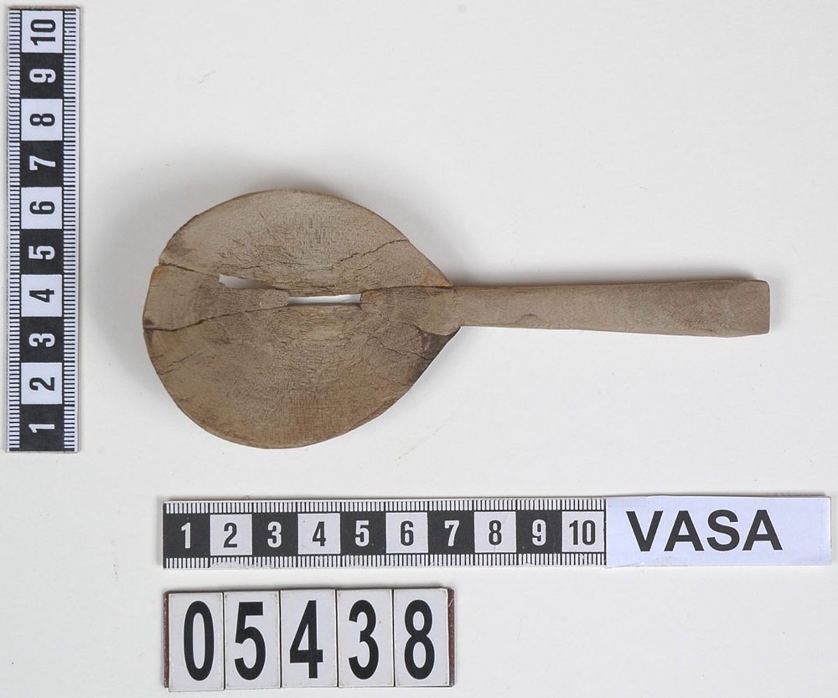 En träsked som tidigare var bruten i fyra delar. En av delarna utgör skaft samt mindre parti av skedblad. De tre övriga är delarna av skedbladet.
Idag är delarna sammanfogade och i sin helhet har skeden ett runt skedblad och ett rakt skaft där tvärsnittet är något ovalt.
Skeden är mycket ömtålig. Ett mindre parti av skedbladet saknas.