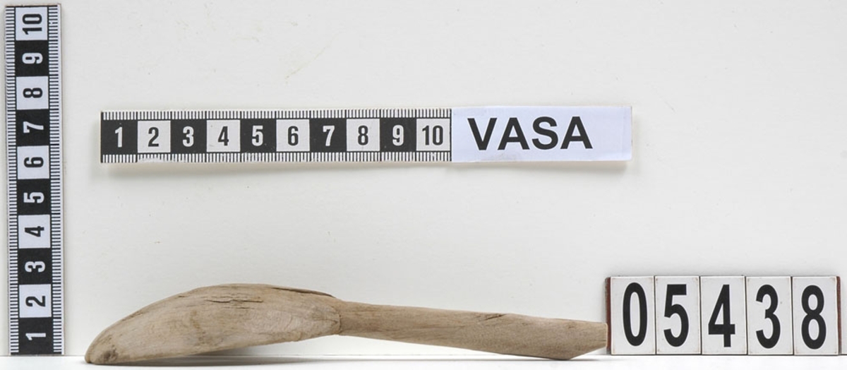 En träsked som tidigare var bruten i fyra delar. En av delarna utgör skaft samt mindre parti av skedblad. De tre övriga är delarna av skedbladet.
Idag är delarna sammanfogade och i sin helhet har skeden ett runt skedblad och ett rakt skaft där tvärsnittet är något ovalt.
Skeden är mycket ömtålig. Ett mindre parti av skedbladet saknas.