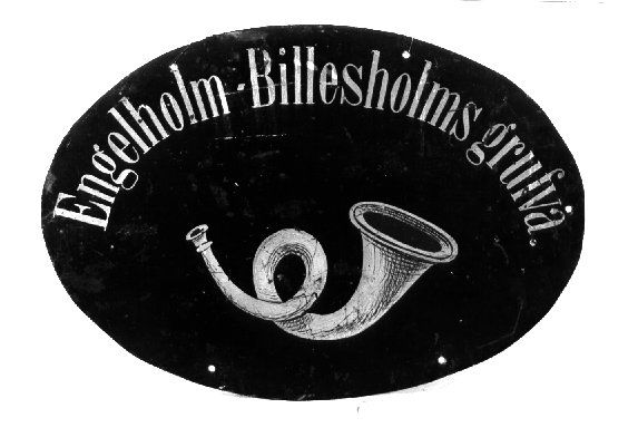 Skylt, oval, av järnbleck, för postfack på järnväg. Med text
"Engelholm - Billesholms grufva" i antikvastil längs övre kanten.
Under texten ett posthorn med munstycket åt vänster. Både texten och
hornet i gul färg. Skylten har sex hål för fastsättning.