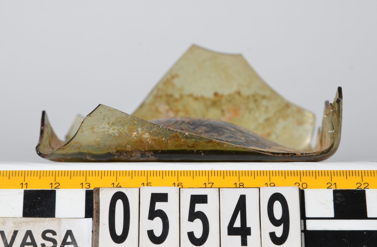 Botten till fyrsidig glasflaska. Glaset är grönfärgat.

2015: 05549a broke into three smaller pieces during handling, labled 05549 a, b, c. 05549a-d have moderate scaling.  All pieces are light green in color, and 05549d has pontil mark.