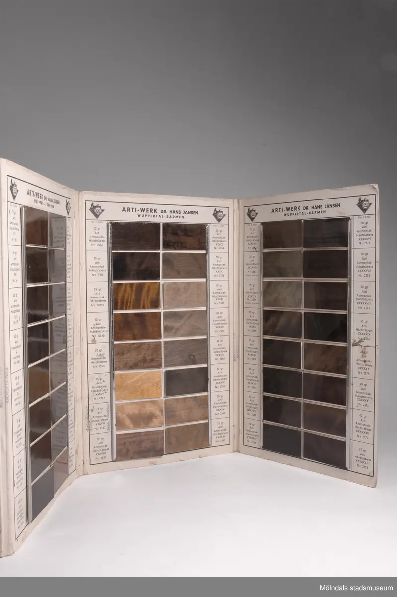 Provkarta med möbelfärger från tyska Art A.G./Barmen, Specialfabrik för träbetsor.Redskap och verktyg kommer från Lindströms snickeri (Gamla Riksvägen 81, Ekebacken). Här byggde John Lindström från Lindome ett boningshus och snickeriverkstad 1928. Han öppnade ett snickeri som specialiserade sig på köksbord Borden levererades till en grossist i Göteborg. Som mest tillverkades 50-60 bord i veckan. Borden hade ben av björk och resten var av furu. Han gjorde även andra möbler på beställning. Till hjälp hade John ett par anställda.De sista åren gjordes mest renoveringar och reparationer, medan det "begav sig" de mest aktiva åren tillverkades bord av alla de slag.