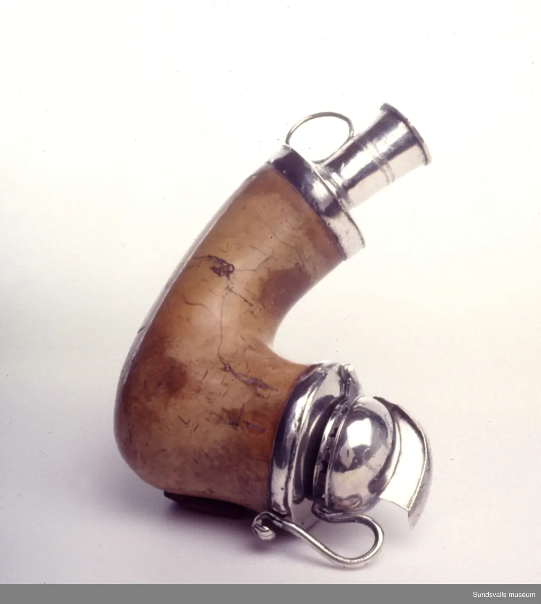 Sjöskumspipa med silverbeslag. Locket i form av en romersk hjälm. Initialer 'I.S.S.' och 'I.P.S' på hjälmen.