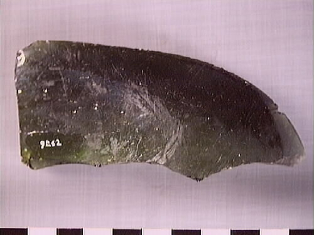 En flaskhals samt en glasskärva.  Flaskhalsen är brunfärgad. Vid flaskmynning ligger glassträngen omlott. Glasbiten är grönfärgad. Troligtvis rör det sig om skärva från flaskans buk. Flaskhalsen och glasskärvan härrör från två olika flaskor.

09262a: Finish has laid-on ring, common on bottles before 1850s (https://sha.org/bottle/finishes.htm), finish also has possible mold line, possibly intrusive artifact. Glass is olive color.
09262b: Glass is dark green.