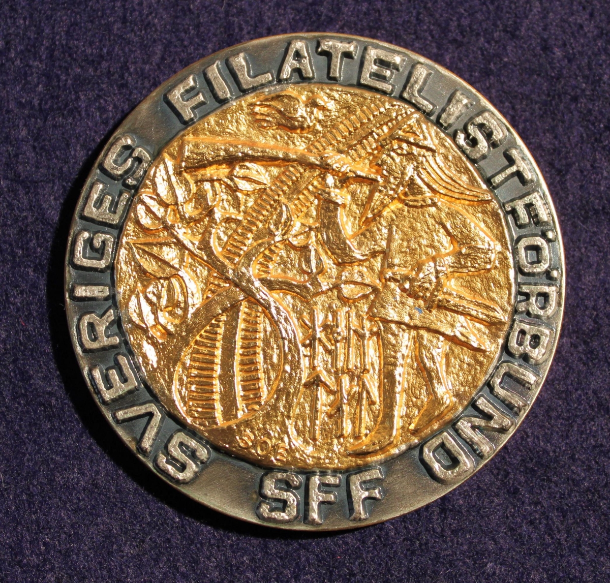 Medalj i förgyllt silver mestadels, rund. Vermeil - medaljen tilldelad Postmuseum för deltagande i frimärksutställning Sol-phil 93i Solna 3 september - 5 september 1993. Åtsidans kant där text enligt MRK står är inte förgylld. Motivet i centrum visar en hornblåsande viking, runor, en duva och trädgrenar. Konstnärssignatur: "SOE" nederst (Svenolov Ehrén). Frånsidan är helt förgylld och bärtext enligt MRK.