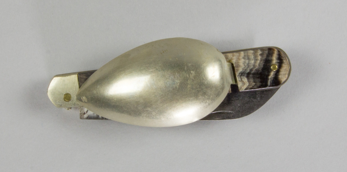 Bestick, fällkniv med handtag av horn och knivblad av stål, sked och gaffel av försilvrad metall, samt dessutom korkskruv och handskknäppare. Signerad: '59 Sauvagnat'.